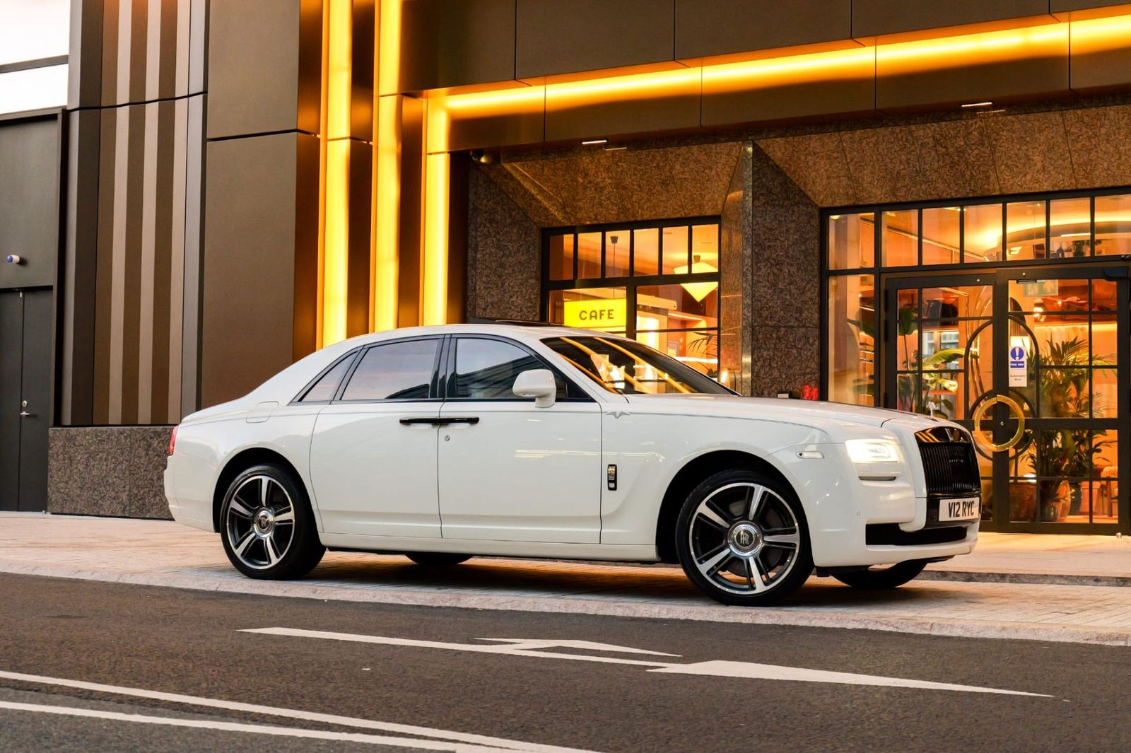 White Rolls-Royce Ghost parked outside a luxury hotel